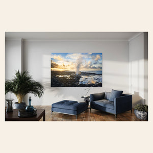 A piece of Kauai art showing a Spouting Horn photo hangs on a living room wall.
