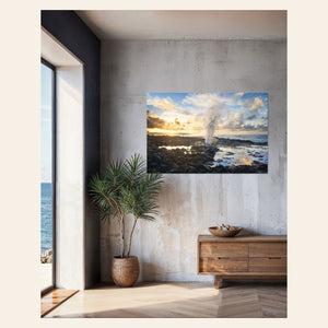 A piece of Kauai art showing a Spouting Horn photo hangs in a living room.
