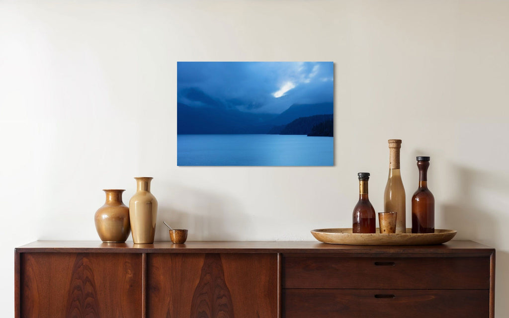 A piece of Vancouver Island art showing a lake photo hangs above a console.