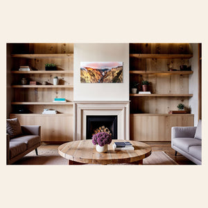 A piece of Yellowstone art showing a canyon photo from Artist Point hangs above a fireplace.