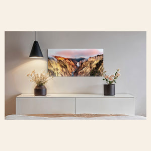 A piece of Yellowstone art showing a canyon photo from Artist Point hangs above a console.