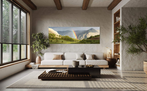 A piece of Colorado art showing a rainbow on Cottonwood Pass hangs in a living room.