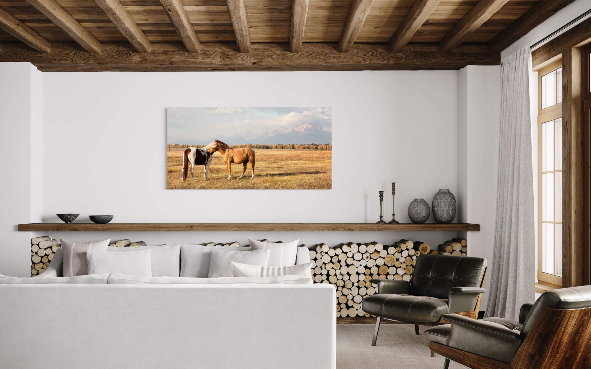 A piece of Jackson Hole art showing horses in Grand Teton National Park hangs in a living room.