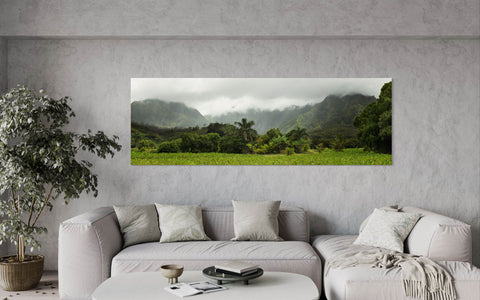 A piece of Kauai art showing the surf town of Hanalei hangs in a living room.