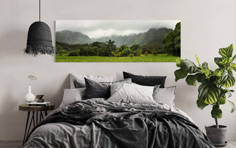 A piece of Kauai art showing the surf town of Hanalei hangs in a bedroom.