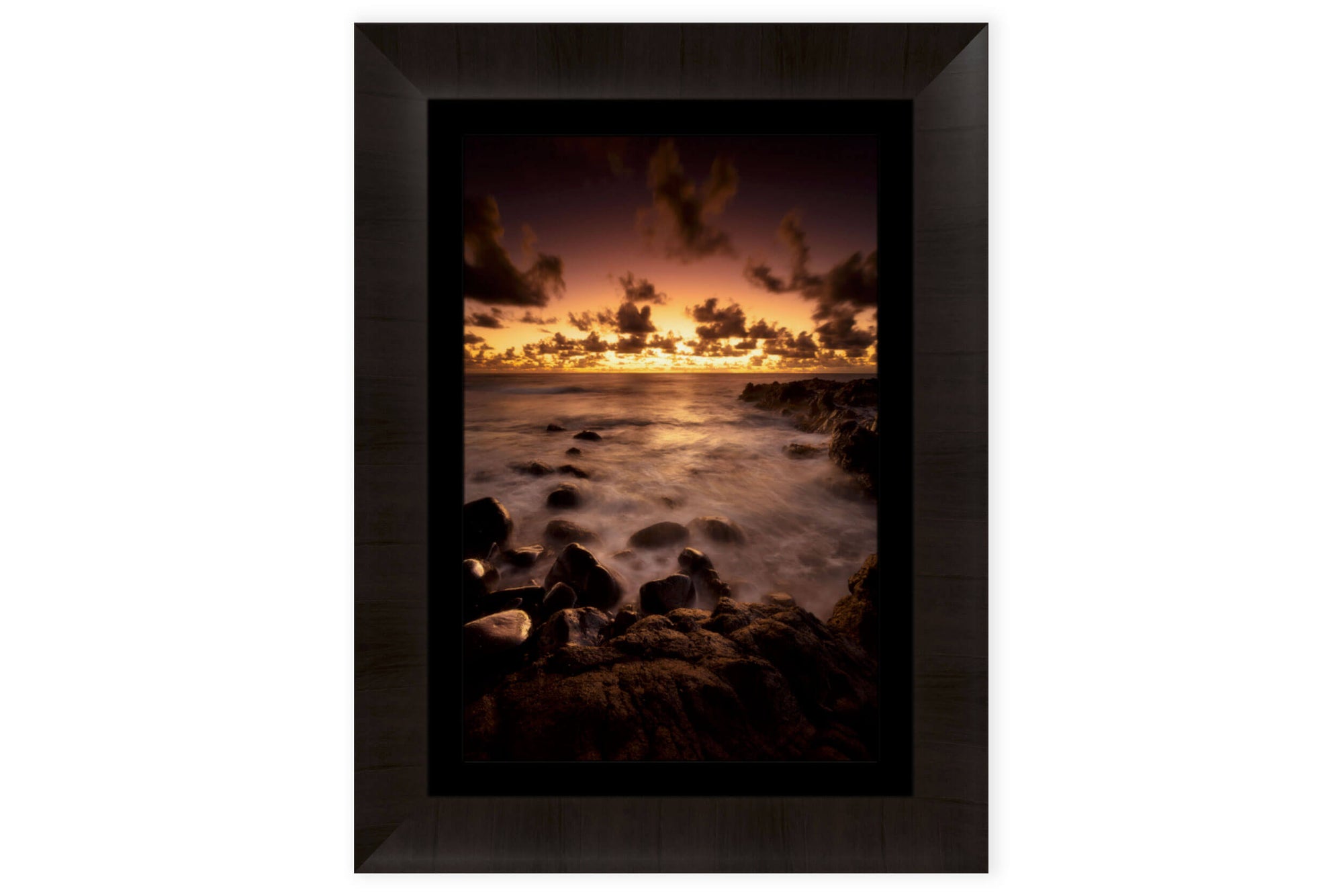 A piece of framed Kauai art shows a Kapaa sunrise picture.