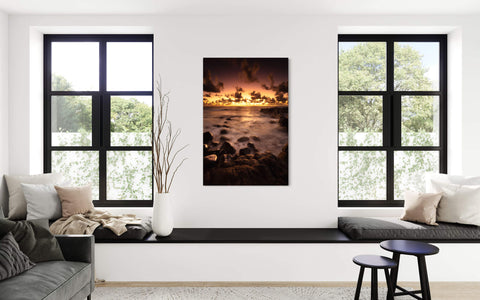 A piece of Kauai art showing a Kapaa sunrise picture hangs in a living room.