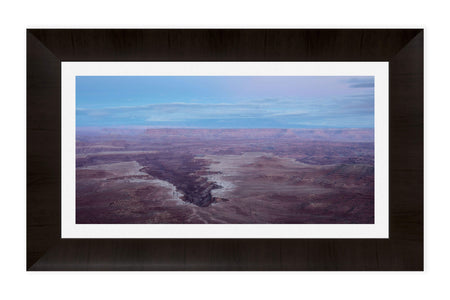 A piece of framed Moab art shows a Canyonlands National Park picture at sunset.