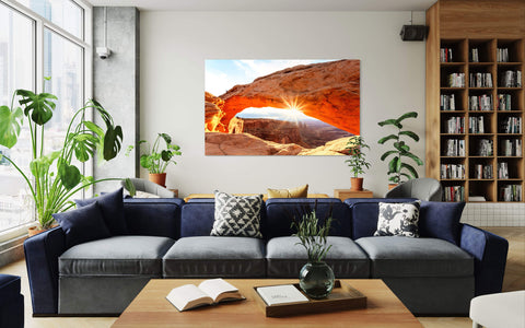 A piece of Moab art showing a Mesa Arch picture hangs in a living room.