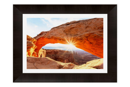 A piece of framed Moab art shows a Mesa Arch picture.