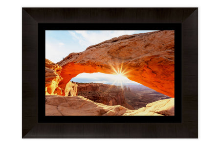 A piece of framed Moab art shows a Mesa Arch picture.