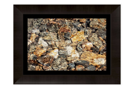 This piece of framed Telluride art shows glistening rocks in a Colorado River.